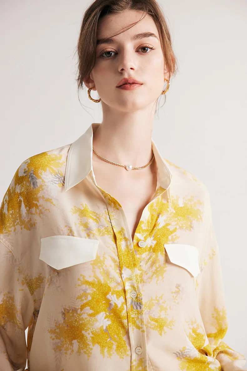 Upper view of a model wearing 100% Mulberry Silk Print Shirt featuring a dawn pink background with delicate yellow blooms, contrast collar, and bold accents. From Borcelleclothes.