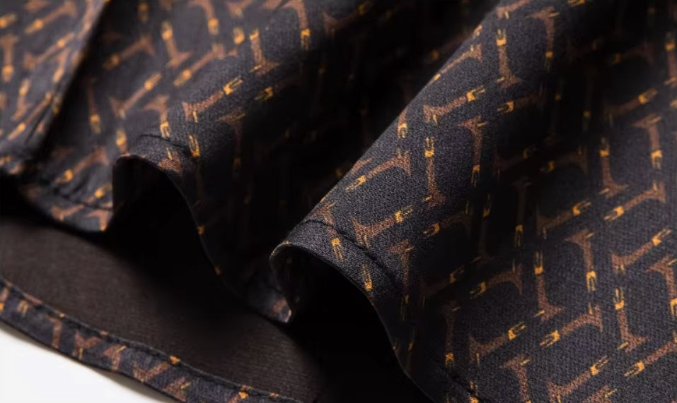 Detailed stitching and textured fabric on the bottom of the Men's Mulberry silk shirt in English Walnut featuring a unique geometric design with intricate rhombuses and vibrant orange accents. The shirt combines luxurious fabric with refined elegance, perfect for a sophisticated look. From Borcelleclothes.