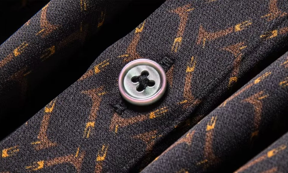 Detailed stitching and textured fabric on the part of the placket with button of the Men's Mulberry silk shirt in English Walnut featuring a unique geometric design with intricate rhombuses and vibrant orange accents. The shirt combines luxurious fabric with refined elegance, perfect for a sophisticated look. From Borcelleclothes.