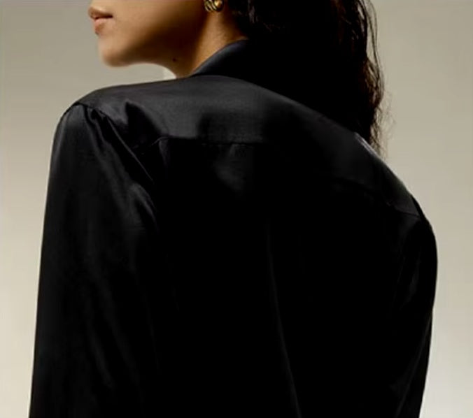 Detailed stitching and textured fabric on the back yoke of a Women's Business Midweight Satin Silk Shirt in Onyx, crafted from 100% Mulberry silk with a luxurious midweight satin finish. The shirt showcases a smooth, lustrous texture that offers elegance and sophistication, ideal for formal and professional settings. From Borcelleclothes.