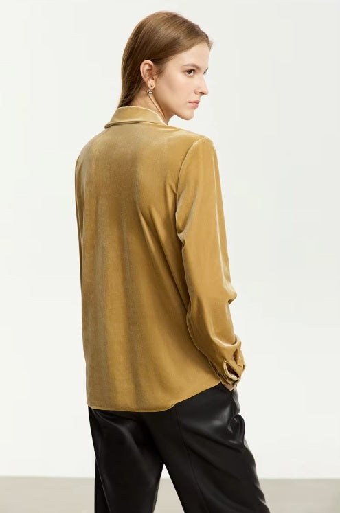 The back of a Women's Silk Velvet Shirt in Camel, crafted from a luxurious silk and viscose blend. Featuring a soft gloss, breathability, a notched collar, single-breasted closure, and left-side flap pocket, this health-conscious velvet shirt offers elegance and comfort for professional and casual wear. From Borcelleclothes.