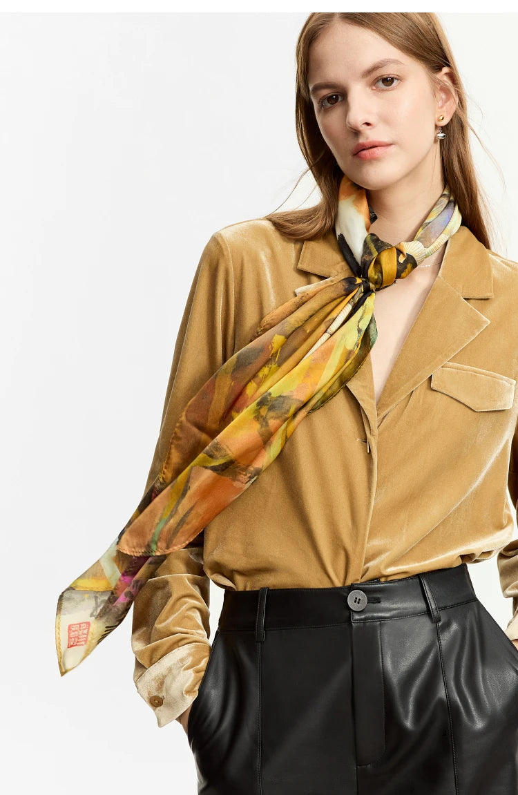 Women's Silk Velvet Shirt in Camel, paired with a fine scarf, crafted from a silk and viscose blend. The modelās ensemble highlights the shirt's soft gloss, notched collar, and luxurious yet comfortable fit, perfect for professional and casual elegance. From Borcelleclothes.