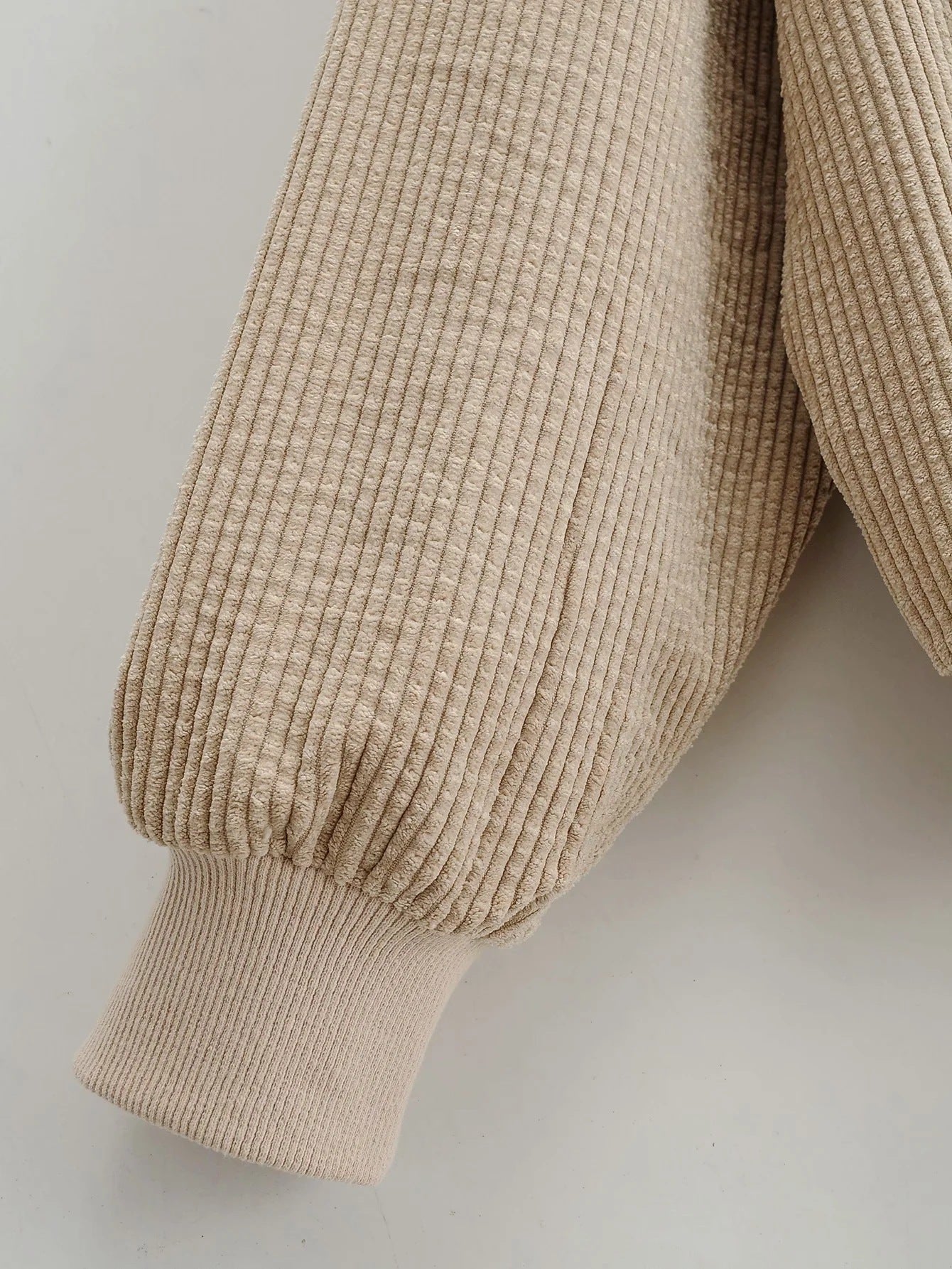 The ribbed cuff of Women's Wide Wale Corduroy Sweatshirt in Coral Reef, designed with cargo flap pockets, drawstring hood, and elastic ribbed cuffs and waistband for a relaxed, stylish fit. From Borcelleclothes.