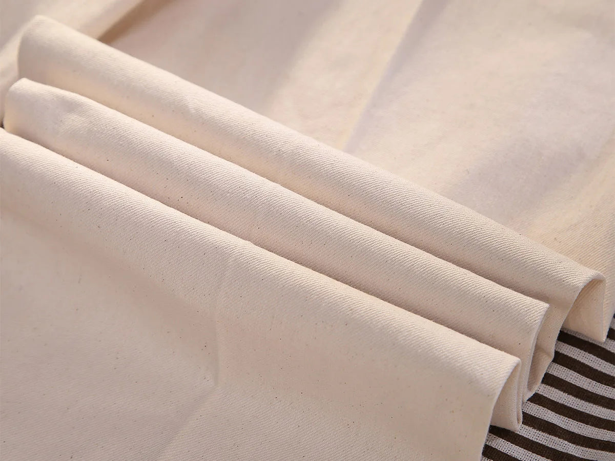 Wave-folded dense cotton fabric in Swiss Coffee shade, highlighting its soft texture and ability to hold shape. From Borcelleclothes.