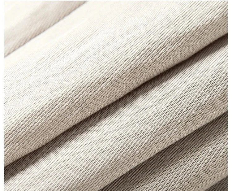 Close-up of Swiss Coffee fabric in soft wave folds — textured surface with a calm, creamy tone. From Borcelleclothes.