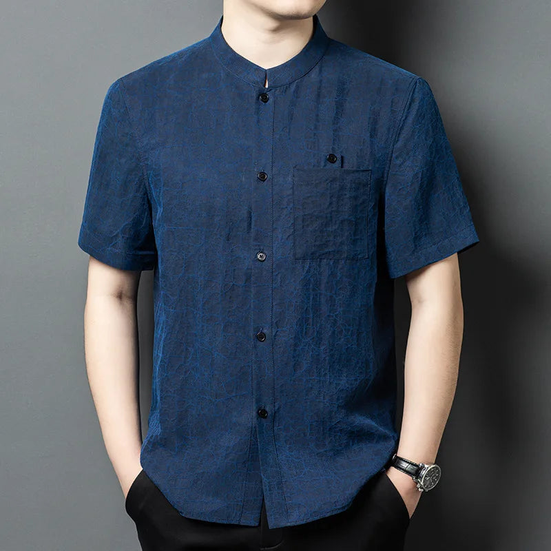 Men's reversible shirt-jacket in Neon Indigo color, made of Xiangyunsha Mulberry silk, highlighting the natural mud-cracked texture with mineral coloration and a structured Mandarin collar. — From Borcelleclothes.