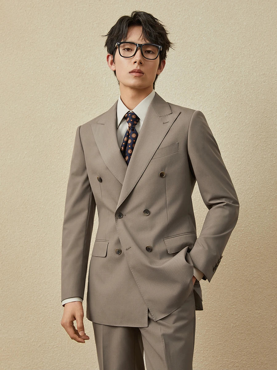 Men’s double-breasted suit in Almond Frost with peaked lapels and horn buttons, worn with quiet poise and modern edge. From Borcelleclothes.