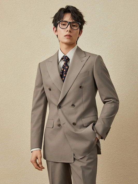 Men’s double-breasted suit in Almond Frost with peaked lapels and horn buttons, worn with quiet poise and modern edge. From Borcelleclothes.
