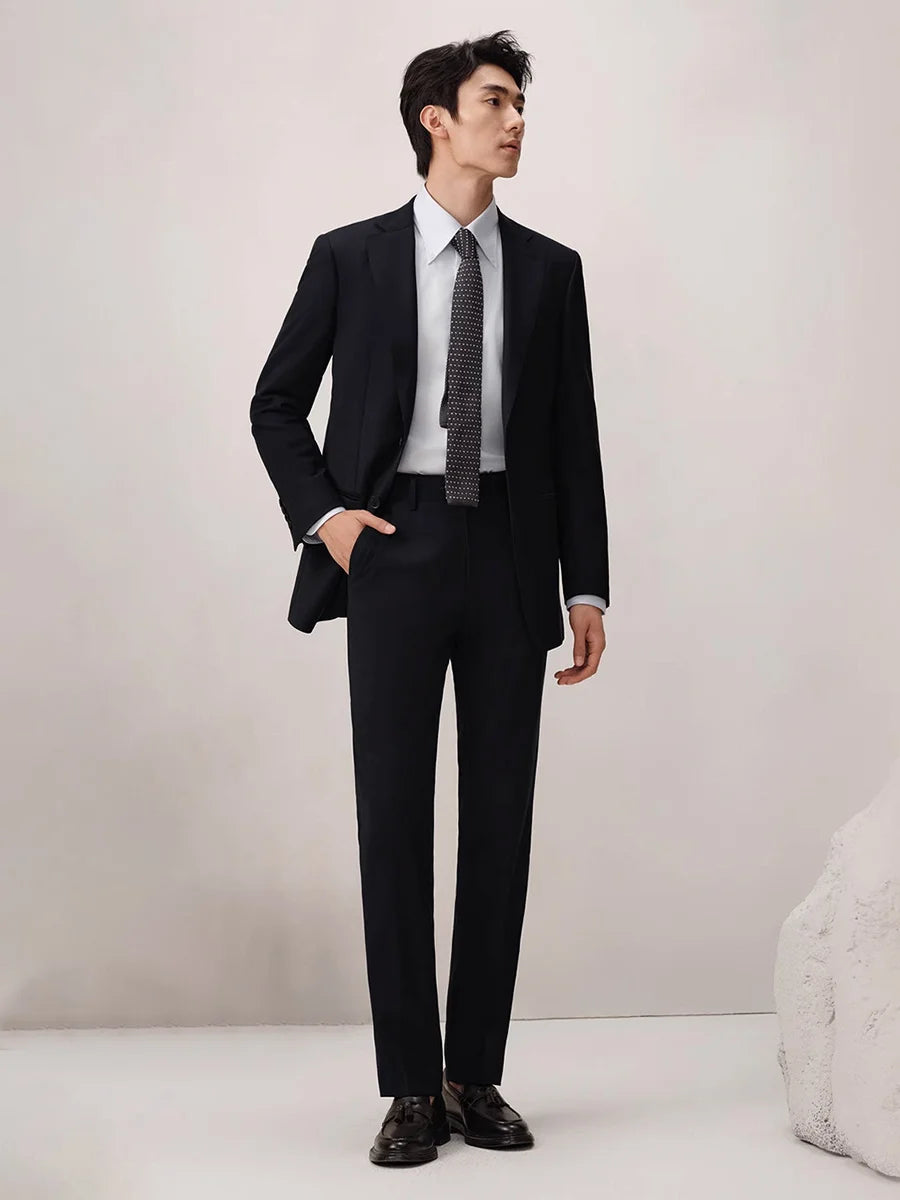 Model in Baltic Sea wool suit glancing to the side, highlighting the blazer’s notch lapels and composed silhouette. From Borcelleclothes.