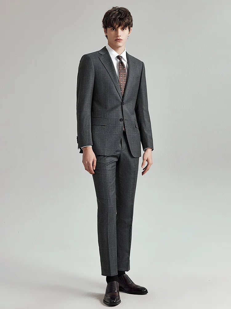 Model in the Borcelleclothes Men's Bright Grey 3-Piece Plaid Suit, stepping forward to highlight the sharp tailoring and straight-leg pants.