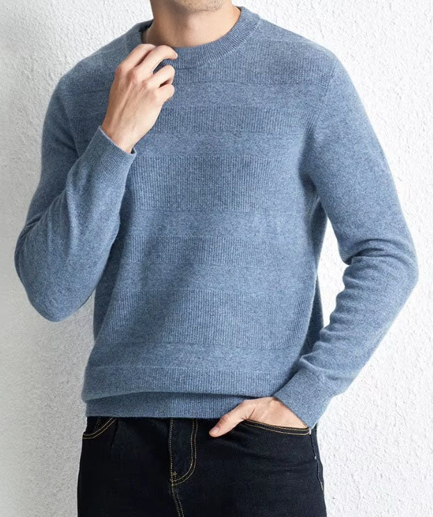 Model wearing the Men's Cashmere Crew Neck Sweater in Rock Blue, touching the ribbed crew neck to highlight its soft and comfortable texture. From Borcelleclothes.