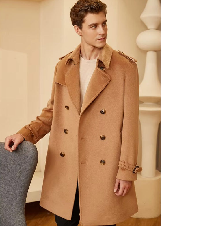 Model wearing the Men’s Cashmere Trench Coat in Burning Sand, lightly touching an armchair, capturing the effortless sophistication of the design. From Borcelleclothes.