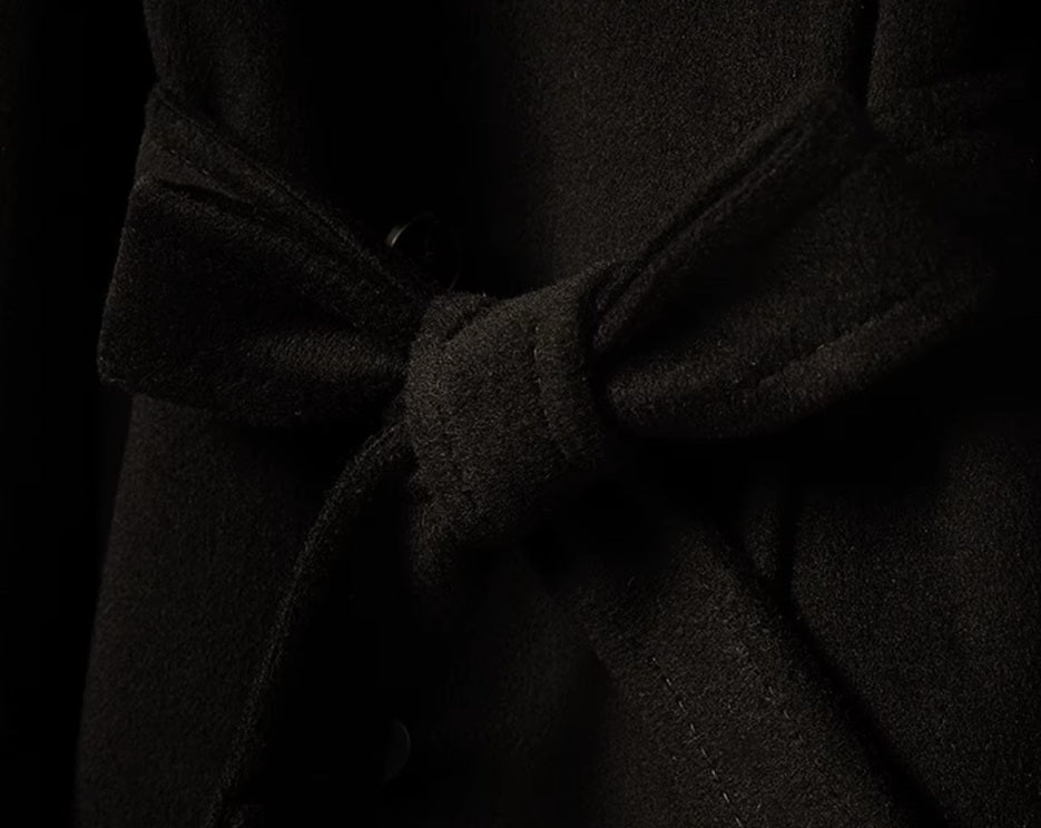 The belt tied in a bow on the Men’s Cashmere Trench Coat in Onyx, emphasizing the adjustable fit and polished finish. From Borcelleclothes.