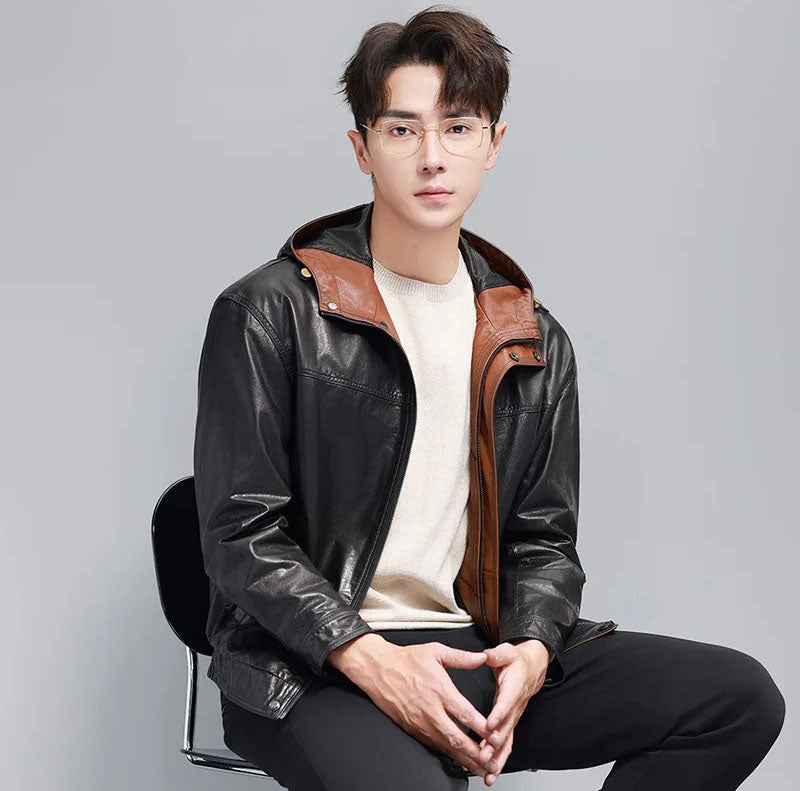 Seated model in men’s cowhide leather jacket; hood open reveals Nutmeg inner facings — From Borcelleclothes.