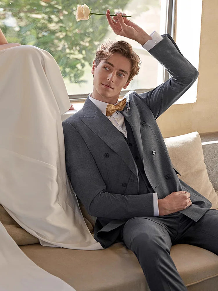 Model in Davy Grey suit holding a white rose, blending restraint with unexpected softness. From Borcelleclothes.