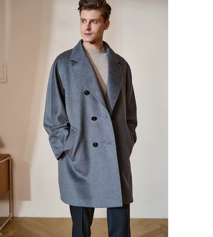 Model wearing the Men’s Double-Breasted Cashmere Coat in Light Slate Grey with hands in pockets, emphasizing the relaxed fit and effortless elegance. From Borcelleclothes.