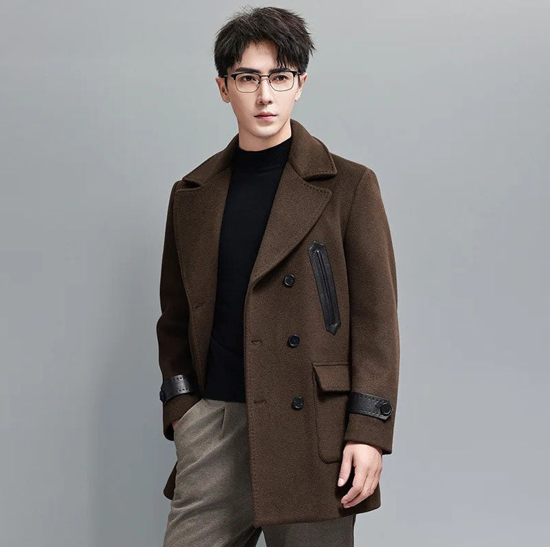 Dark Rum wool-cashmere double-breasted coat with leather trim, model with one hand in pocket. From Borcelleclothes.
