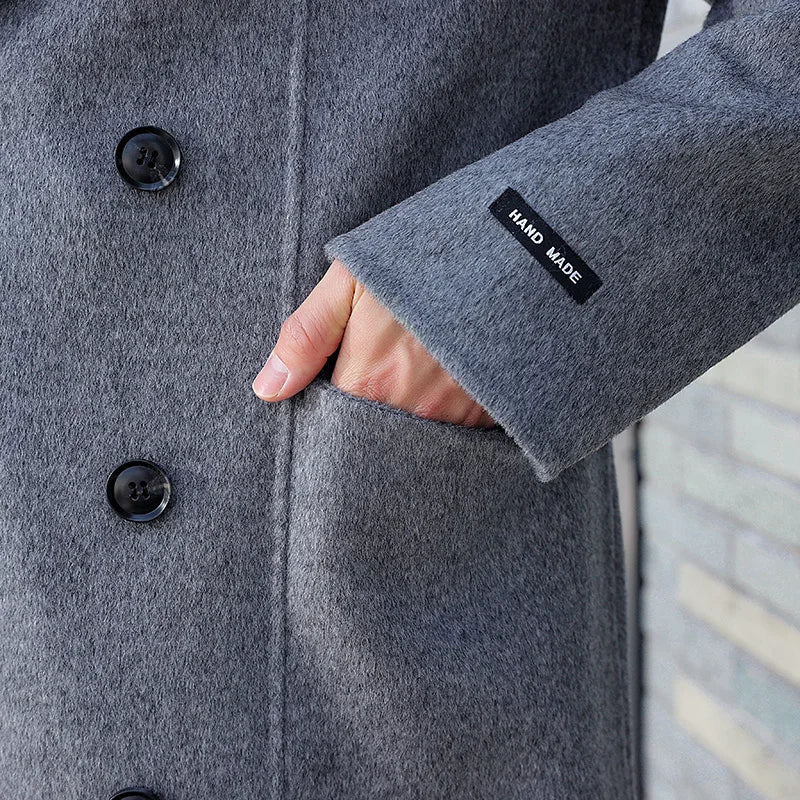The Men’s Double-Sided Wool Coat in Comet, focusing on the patch pocket and "HAND MADE" label, showcasing its craftsmanship and design details. From Borcelleclothes.