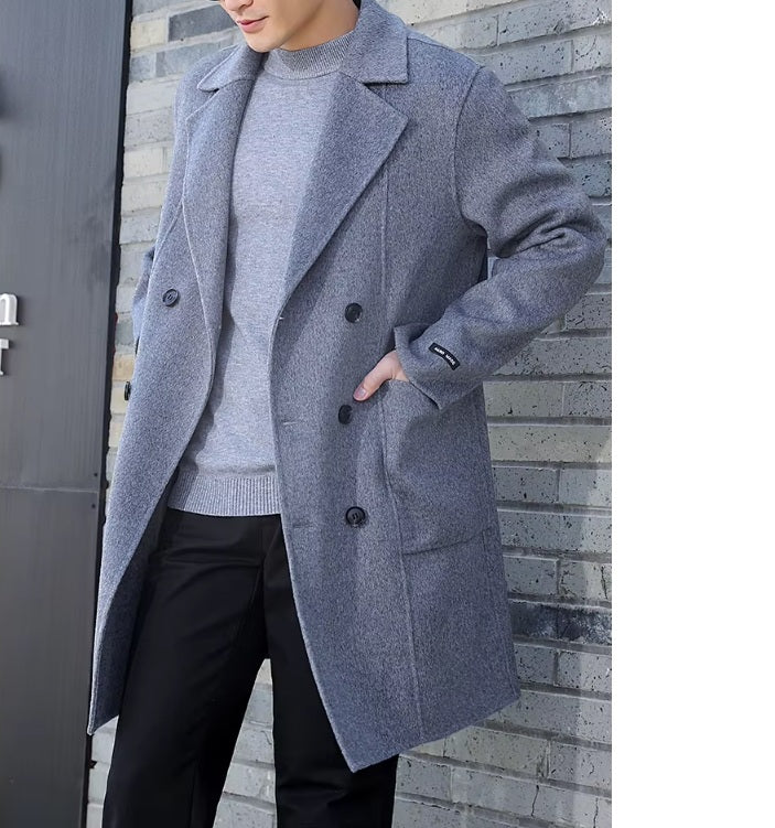 A model wearing the Men’s Double-Sided Wool Coat in Comet, placing a hand in the pocket, highlighting its structured patch pocket design and refined silhouette. From Borcelleclothes.