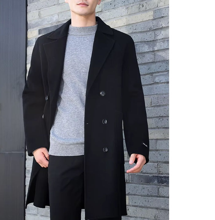 A model wearing the Men’s Double-Sided Wool Coat in Onyx, pushing back the front side, showcasing its refined drape and classic double-breasted structure. From Borcelleclothes.