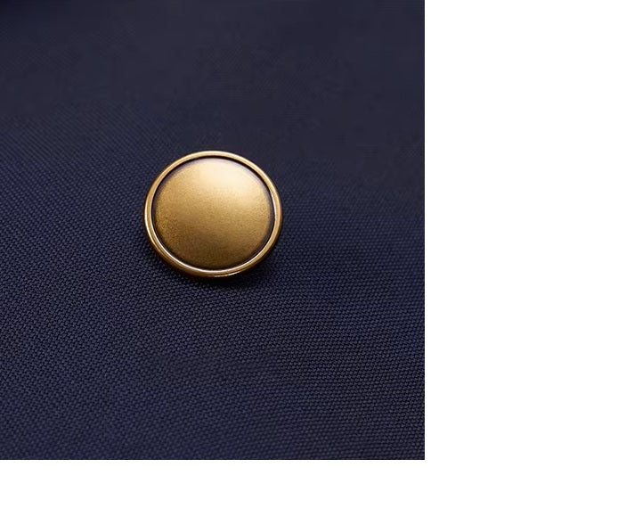 The bold brass button on the blazer of the Borcelleclothes Men's Ebony Clay Suit with Bold Brass Accents, highlighting the luxurious detail and craftsmanship.