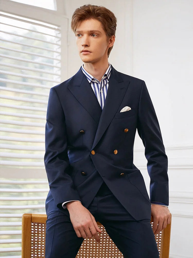 Model sitting on the back of a chair, wearing the Borcelleclothes Men's Ebony Clay Suit with Bold Brass Accents, highlighting the casual sophistication of the blazer and pants.