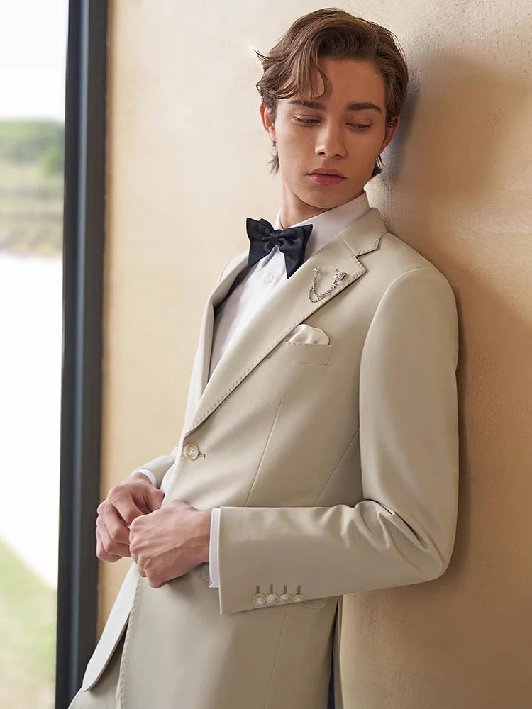 Model wearing the Borcelleclothes Men's Ecru White Suit, lightly touching the front edges of the blazer, emphasizing the refined tailoring and smooth fabric.