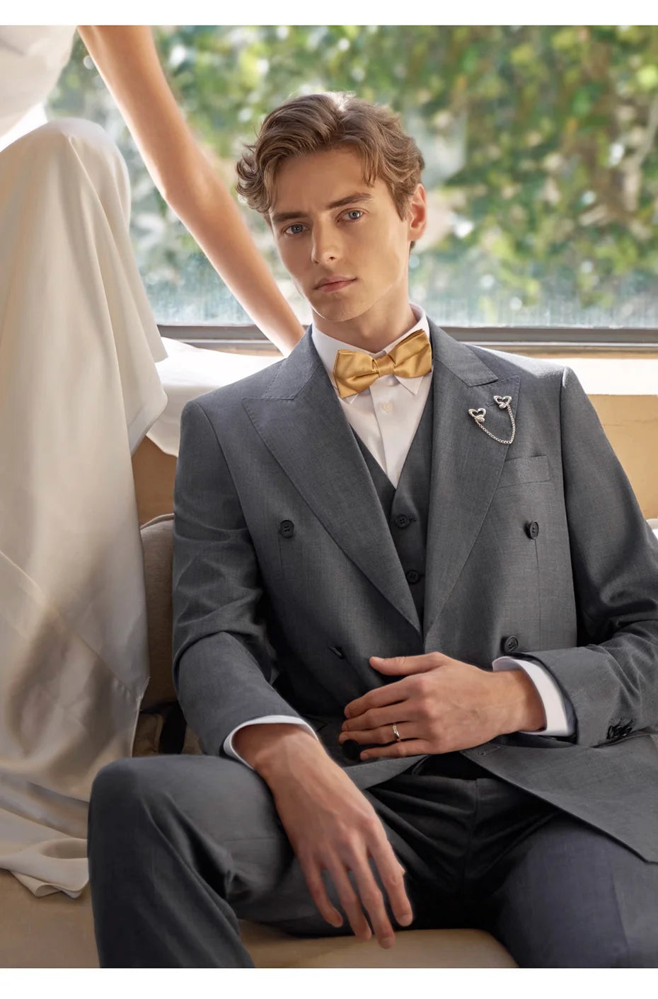 Model in Davy Grey suit sitting on a sofa — still, centered, and untouchable. From Borcelleclothes.