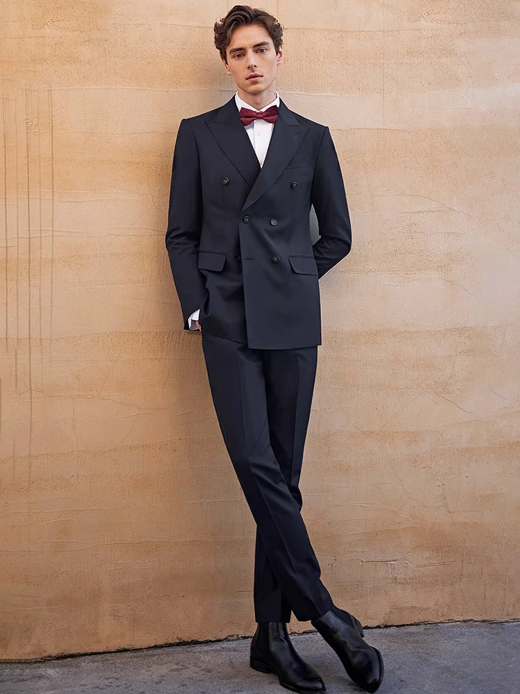 Model in Ebony Clay wool suit sitting with crossed legs — poised, deliberate, and fully composed. From Borcelleclothes.