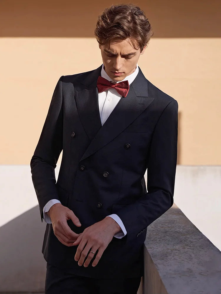 Model in formal suit looking down at his hands — composed, reflective, and quietly unshakable. From Borcelleclothes.