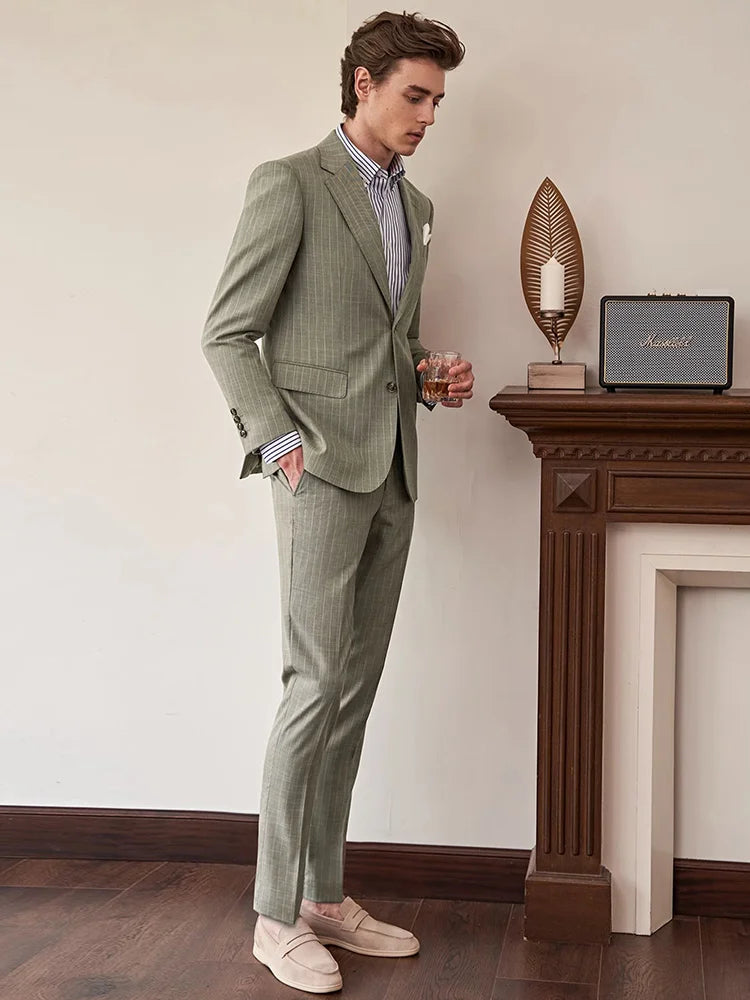 Model in the grey olive pinstripe suit, turned slightly to the side to reveal the suit’s clean silhouette. From Borcelleclothes.