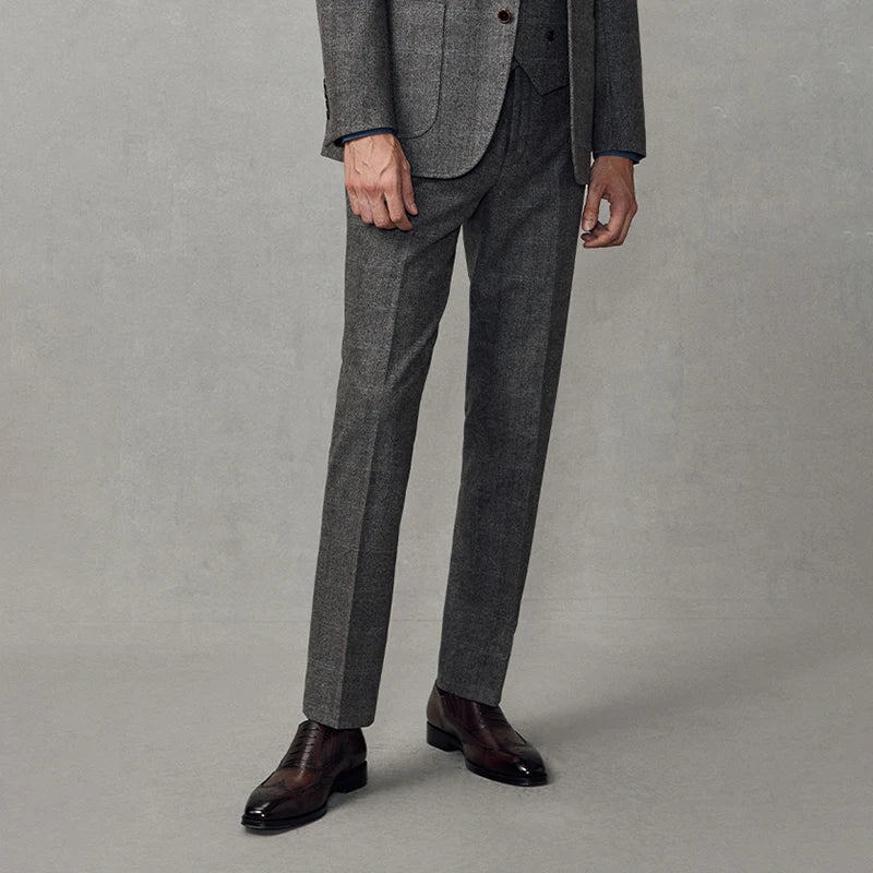 Model wearing cloudy grey wool trousers, steps side showing slim silhouette and natural drape. From Borcelleclothes.