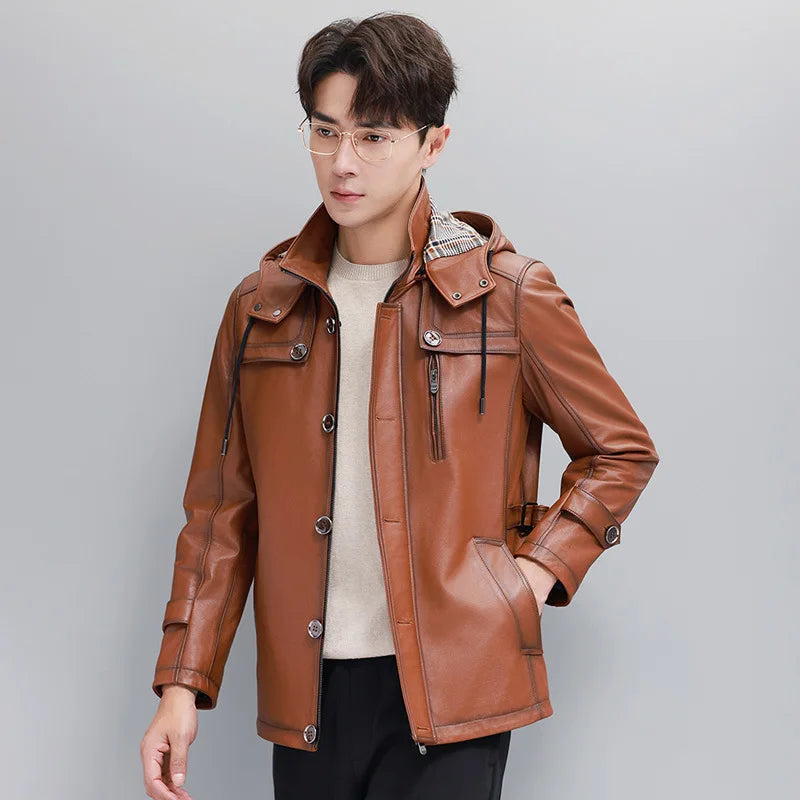 Men’s hooded cowhide leather jacket in Nutmeg with zip-through stand collar, plaid-lined hood, storm-flap accents, sleeve tabs, and ribbed hem. From Borcelleclothes.