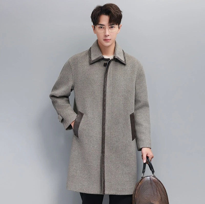 Men’s leather cord weaving wool coat in Mountain Mist, model holding a brown leather duffle bag. From Borcelleclothes.