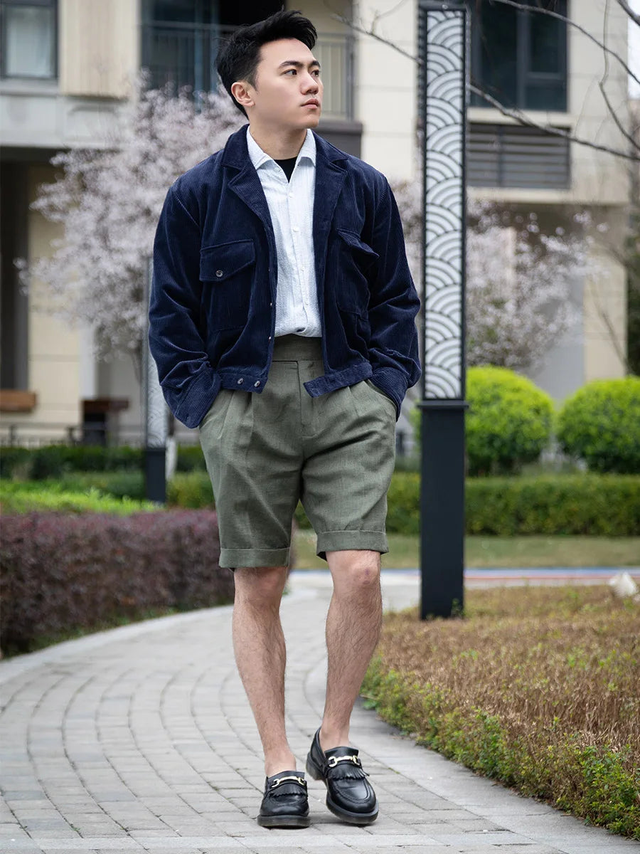 Model with hands in pockets, showcasing the tailored fit and fluid drape of the sage linen shorts. From Borcelleclothes.