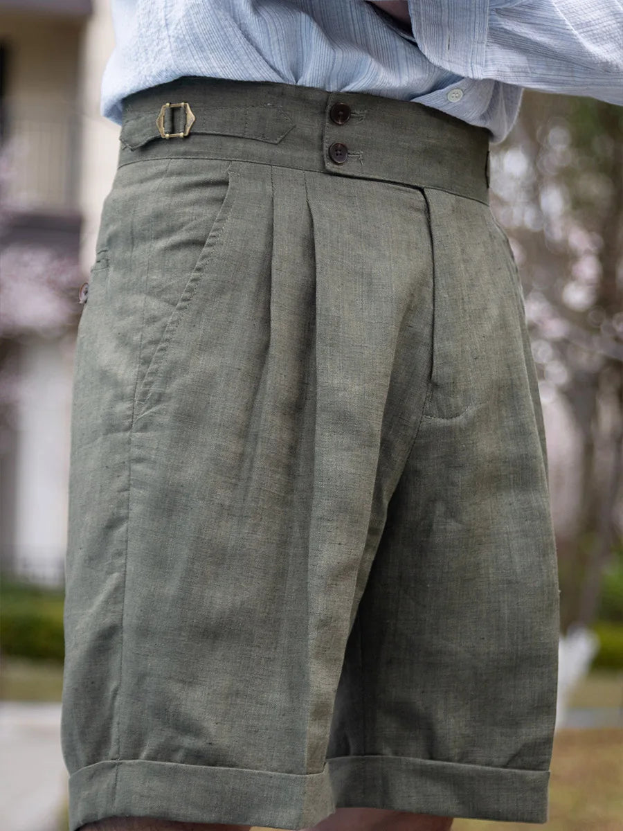 Model wearing sage green linen tailored shorts, turned slightly to the right to reveal the clean side profile. From Borcelleclothes.