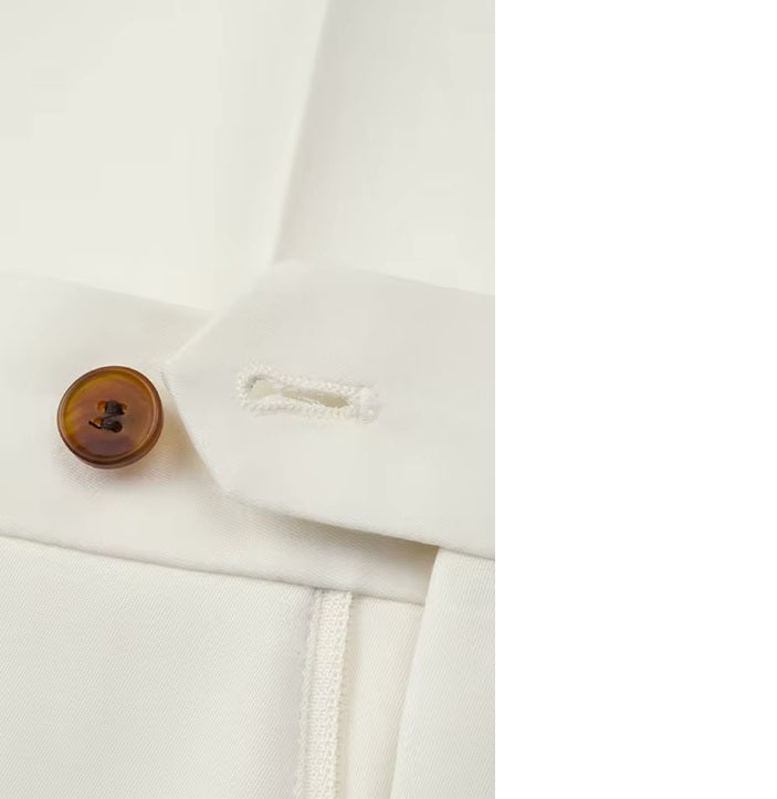 The Men's Luxury Alabaster Suit's pants button and buttonhole, showcasing the handmade tailoring. From Borcelleclothes.