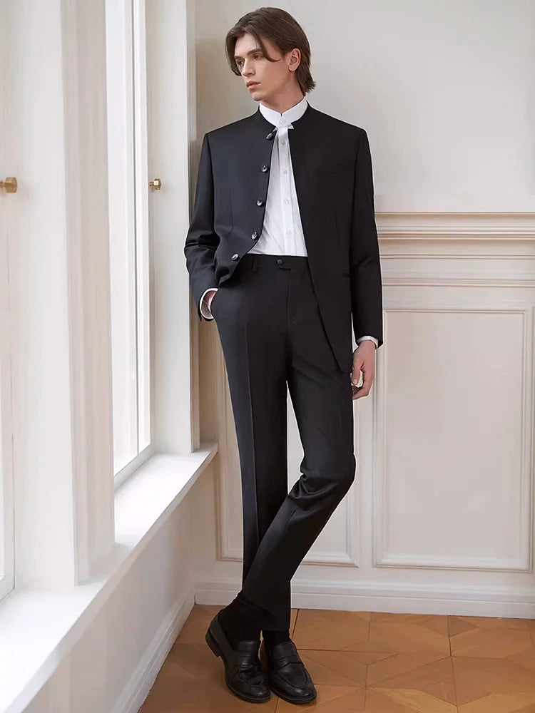 Model in the Borcelleclothes Men's Mandarin Collar Wool Ensemble in Onyx, gazing thoughtfully out of a window, showcasing the suit’s commanding and sophisticated presence.