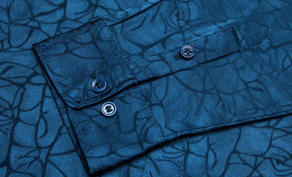 Detailed stitching and textured fabric on the cuff with buttons of the Men's Mulberry Silk Shirt in Chathams Blue, featuring an earth-inspired pattern with a dynamic interplay of matte and shiny finishes, crafted from 92.4% Mulberry silk and 7.6% spandex, ideal for formal and semi-formal occasions. From Borcelleclothes.