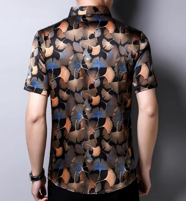 The back of the Men's Nature-Inspired Mulberry Silk Shirt featuring an intricate ginkgo leaves pattern on a rich dark background, showcasing warm earthy shades and blue accents, symbolizing endurance and the beauty of changing seasons. From Borcelleclothes.