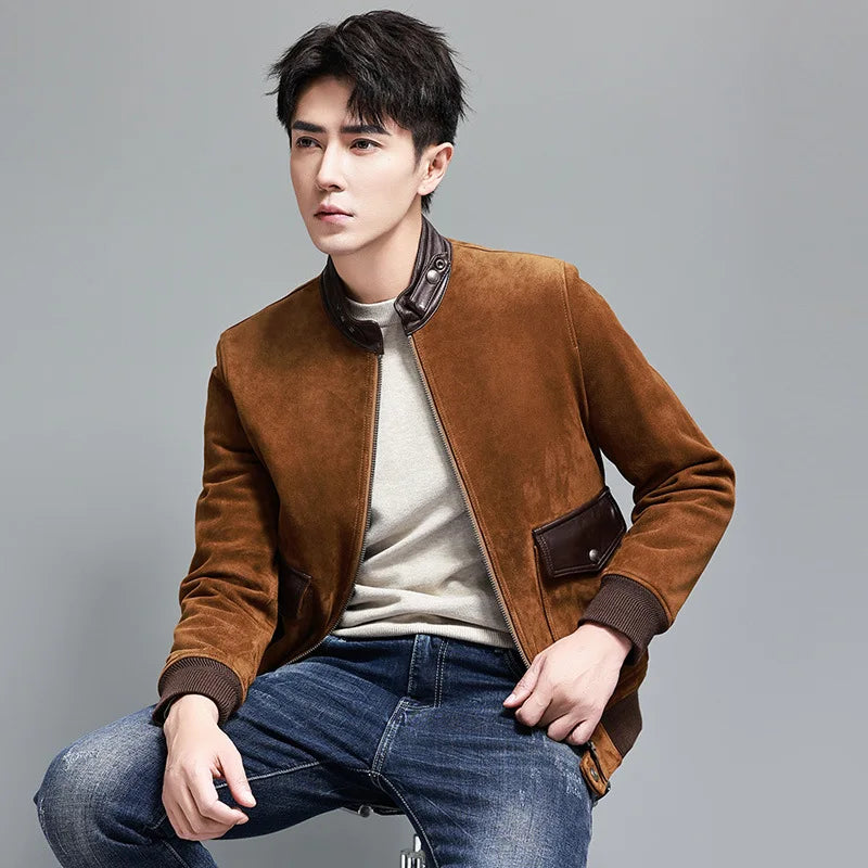 Nutmeg Suede Bomber — model sitting on a chair; calm nutmeg tone, curved flap pockets, tactile suede texture. From Borcelleclothes.