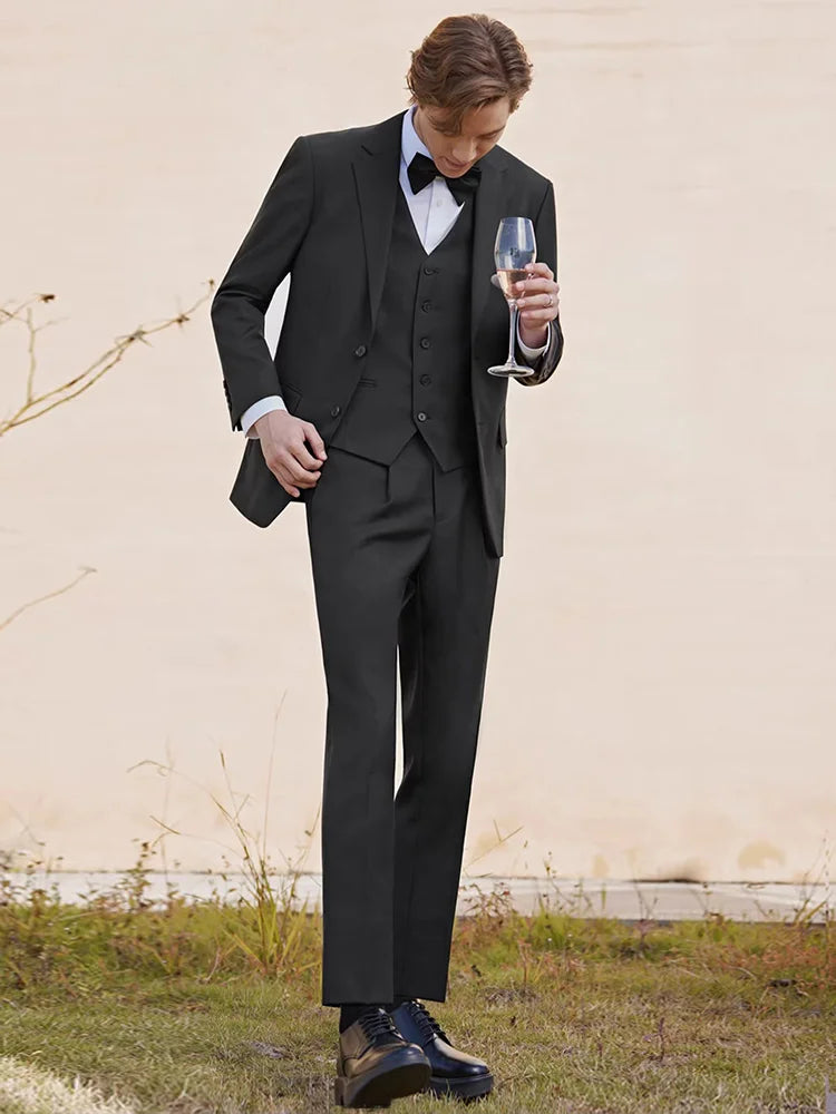 Model in an Onyx wool-blend suit holding a glass of wine, exuding quiet elegance. From Borcelleclothes.