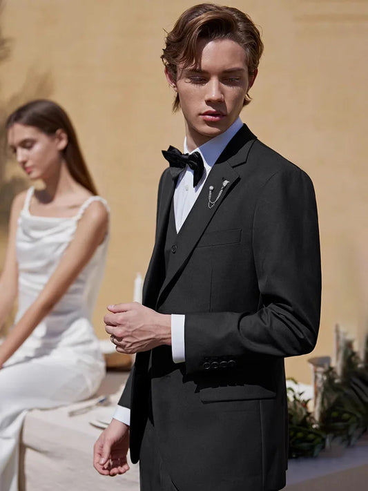 Men’s Onyx wool-blend suit featuring a single-breasted blazer with notch lapels, a buttonhole detail, and pleated trousers with side adjusters. From Borcelleclothes.