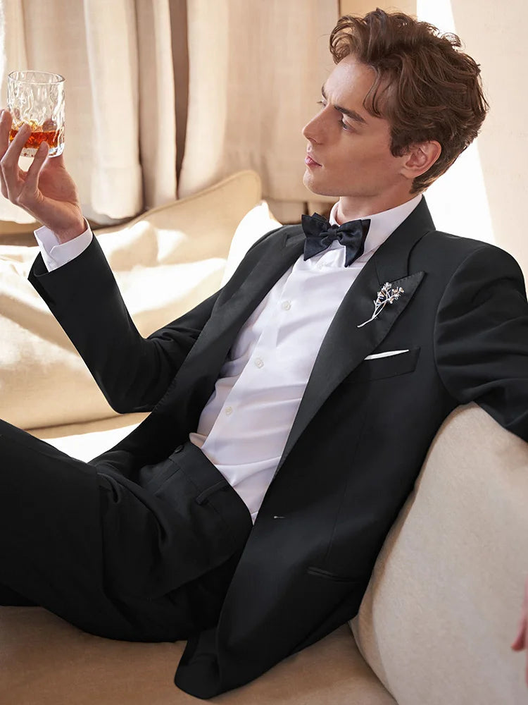 Model gazing at whiskey glass in Onyx Wool Tuxedo — a scene of stillness and sophistication. From Borcelleclothes.