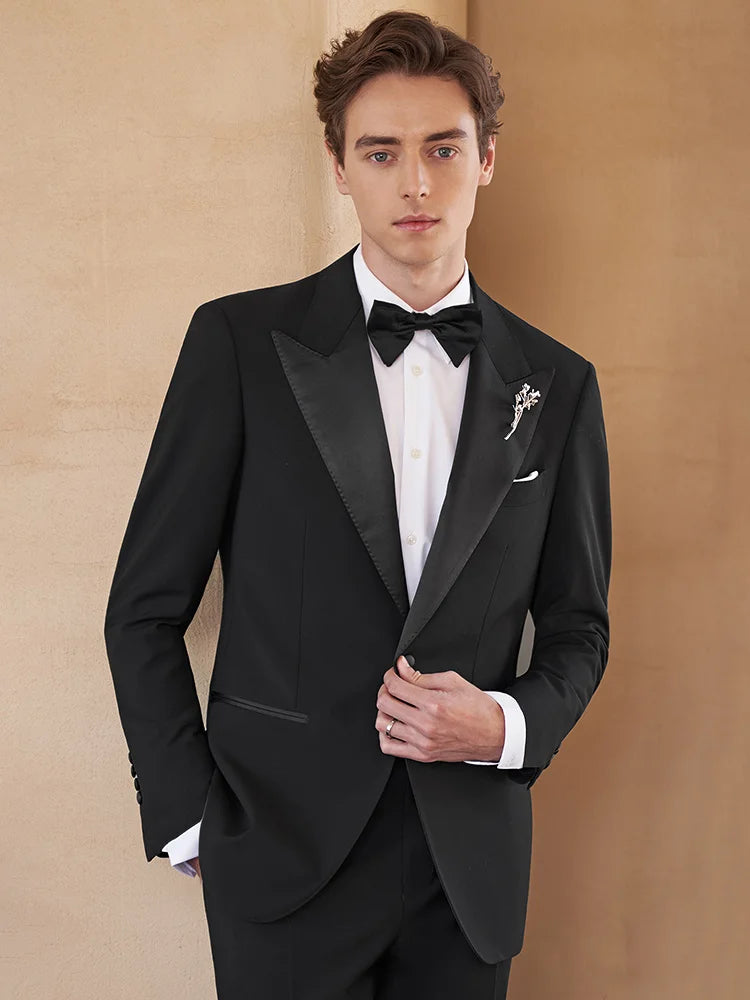 Formal men’s tuxedo in Onyx wool with satin lapels, covered button, and tailored silhouette — a refined evening ensemble crafted for presence and poise. From Borcelleclothes.