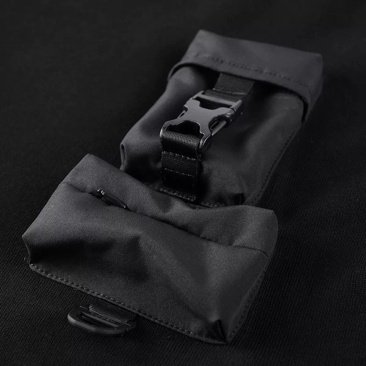 Layered front pouches on the Onyx men's patchwork sweatshirt — one zippered, one with utility buckle. From Borcelleclothes.