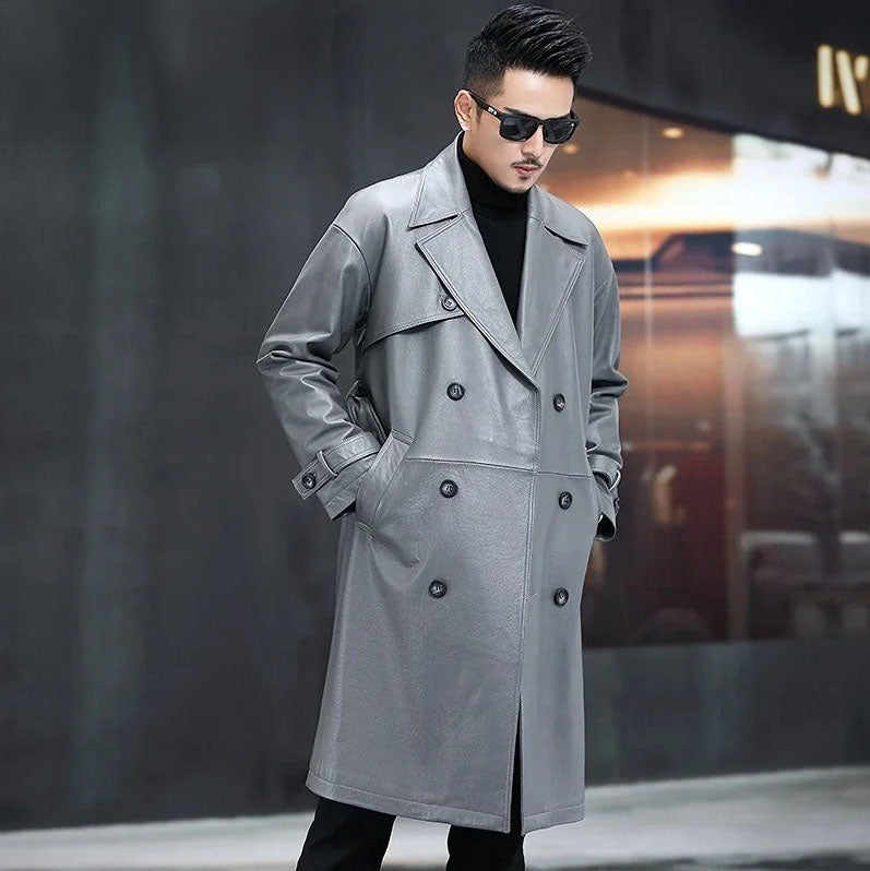 Men’s Regent Grey cowhide leather trench coat, model looking down with hands in pockets — From Borcelleclothes.