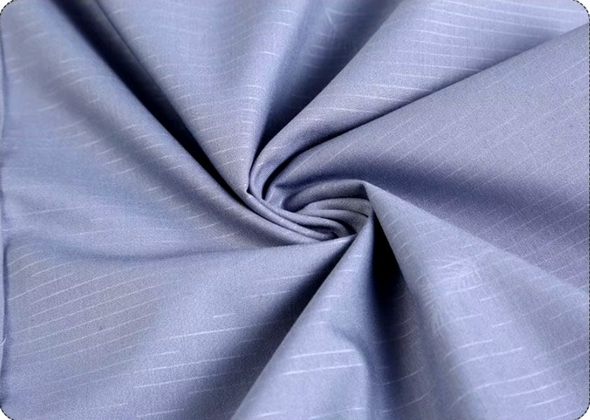 The fabric held and released to demonstrate the natural drape and luxurious texture of the Men’s long sleeve silk shirt in Blue Haze featuring a refined haze pattern with subtle feather accents for an elegant and timeless look. From Borcelleclothes.