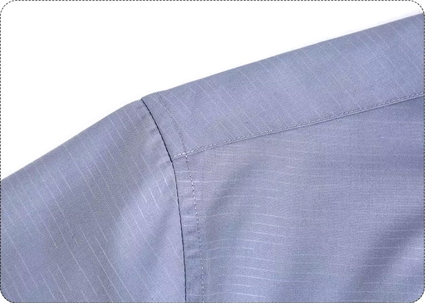 Detailed stitching and textured fabric on the shoulder of the Men’s long sleeve silk shirt in Blue Haze featuring a refined haze pattern with subtle feather accents for an elegant and timeless look. From Borcelleclothes.