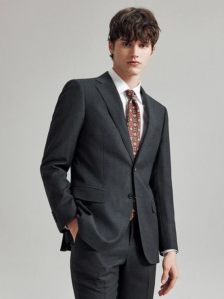 Model wearing the Borcelleclothes Men's Steel Grey Pinstriped Suit with one hand in the pants pocket, highlighting the sleek tailoring and subtle pinstripe design.